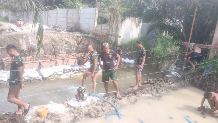 Personel Kodim 0301/Pekanbaru Bersama Warga Atasi Genangan di Area Pengecoran Jembatan