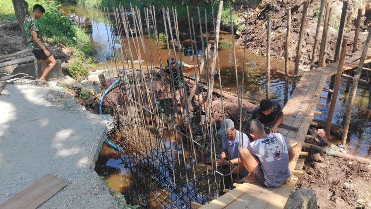 Personel Kodim 0301/Pekanbaru dan Warga Lanjutkan Perakitan Besi Pondasi Jembatan Beton Tahap IV